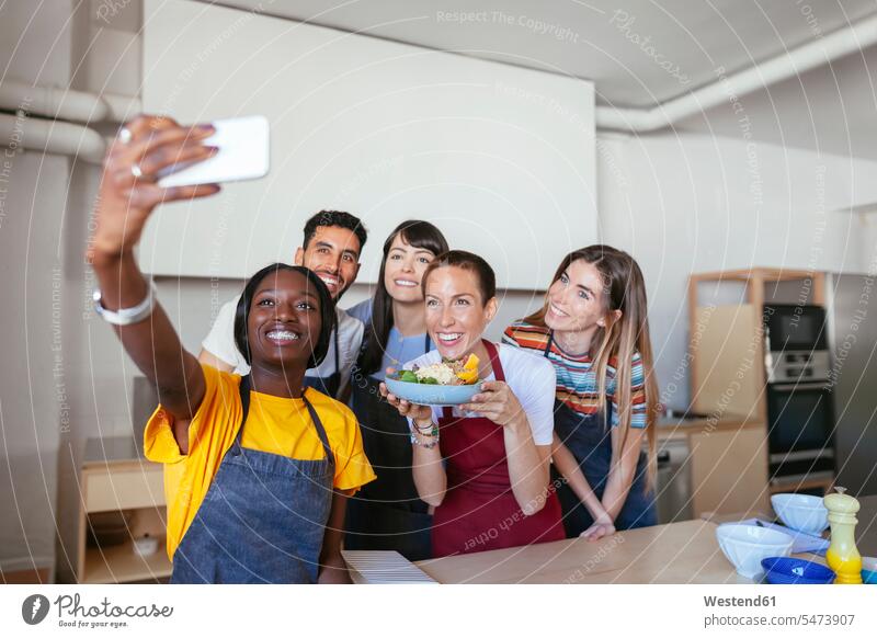 Friends and instructor in a cooking workshop taking a selfie cooking course cooking class cooking lesson Selfie Selfies friends mate kitchen training course