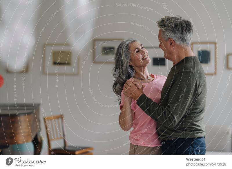 Happy senior couple dancing in living room at home relax relaxing smile relaxation delight enjoyment Pleasant pleasure Cheerfulness exhilaration gaiety gay glad