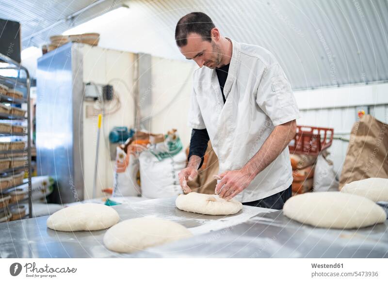 Baker preparing loaves of bread in bakery human human being human beings humans person persons caucasian appearance caucasian ethnicity european