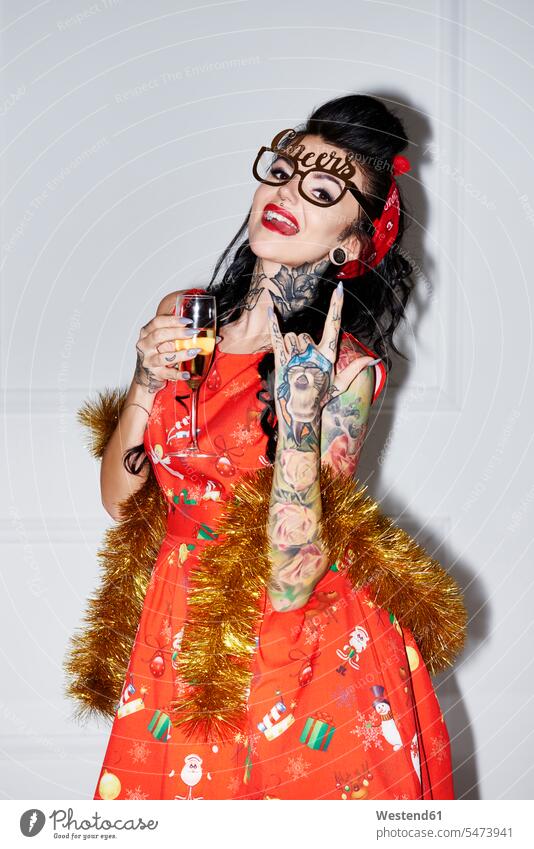 Portrait of tattooed woman with champagne glass showing Rock And Roll Sign females women Rock and Roll rock 'n' roll tattoos portrait portraits Champagne Glass