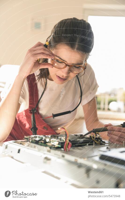 Young woman working on computer equipment at home Germany Printed Circuit Board Competence Skill attention attentive paying attention mounting assembling IT