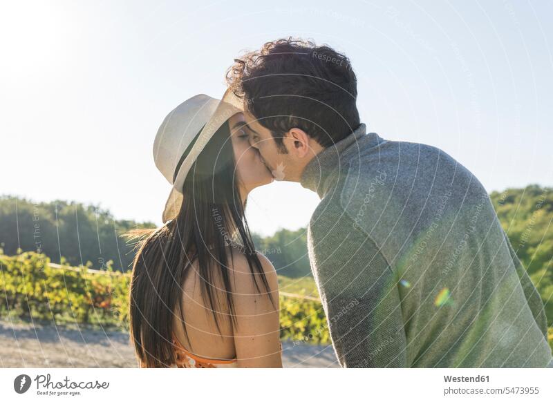 Italy, Tuscany, Siena, young couple kissing in a vineyard kisses twosomes partnership couples people persons human being humans human beings agriculture