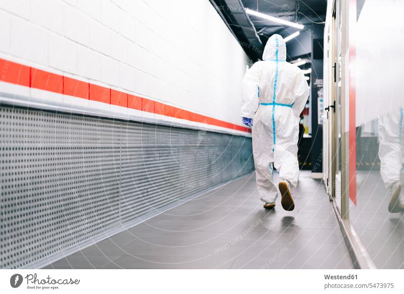 Healthcare man walking while wearing protective suit in hospital color image colour image indoors indoor shot indoor shots interior interior view Interiors