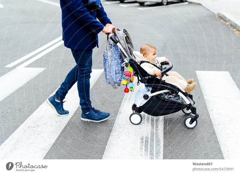 Man with baby stroller crossing road in city color image colour image outdoors location shots outdoor shot outdoor shots day daylight shot daylight shots