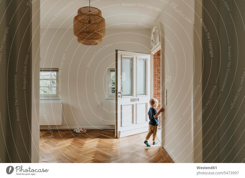 Boy standing by open door at home color image colour image indoors indoor shot indoor shots interior interior view Interiors day daylight shot daylight shots