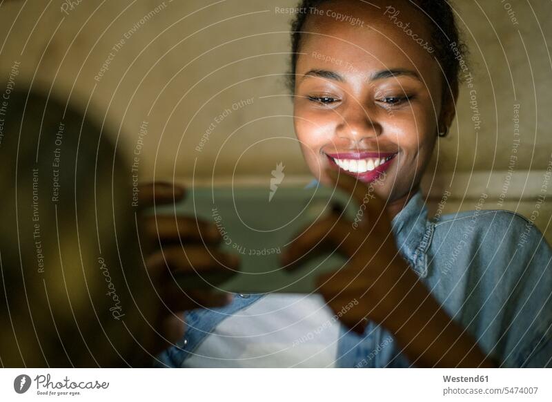 Portrait of happy young woman using smartphone by night, Lisbon, Portugal human human being human beings humans person persons African black black ethnicity