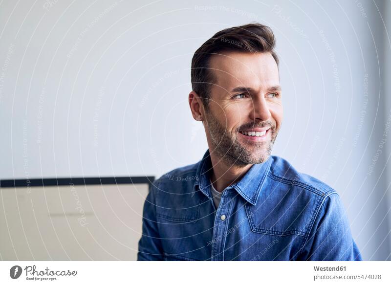 Portrait of smiling man in office looking sideways portrait portraits men males offices office room office rooms sideways glance Sideway Glance side glance