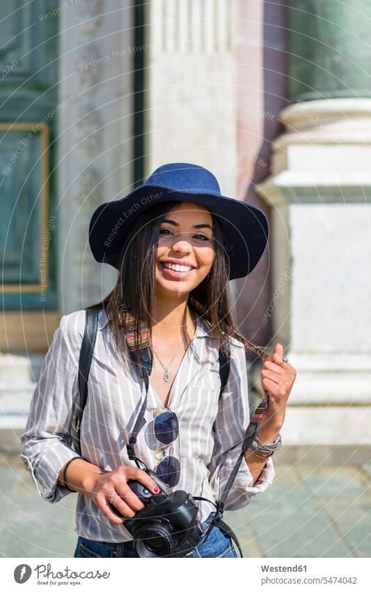 Italy, Florence, portrait of happy young tourist with camera and sunglasses portraits happiness female tourist cameras sun glasses Pair Of Sunglasses woman