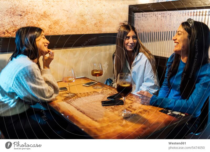 Female friends talking while having drinks in bar color image colour image indoors indoor shot indoor shots interior interior view Interiors 16-17 years