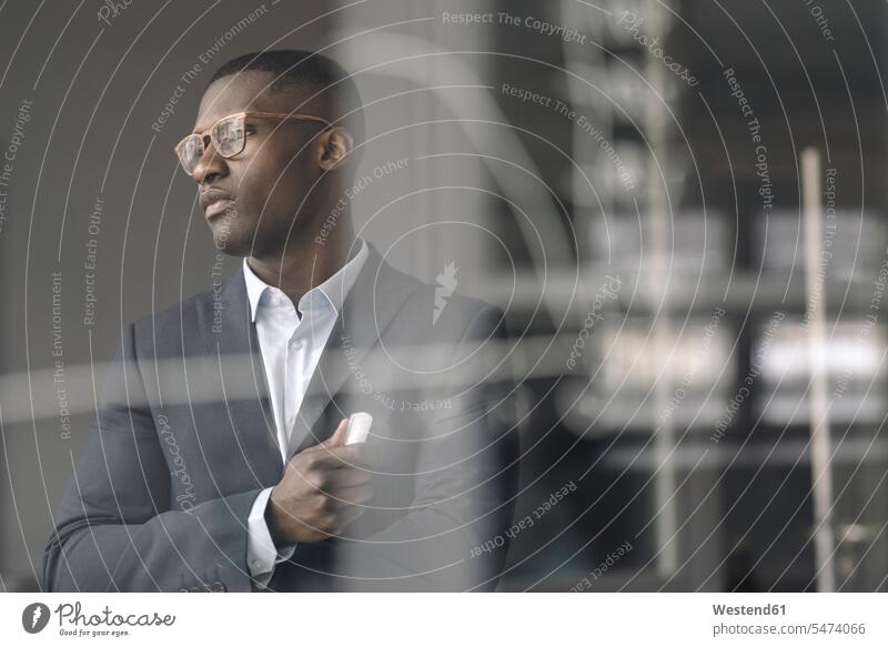 Portrait of young businessman behind diagram on glass pane in office Occupation Work job jobs profession professional occupation business life business world