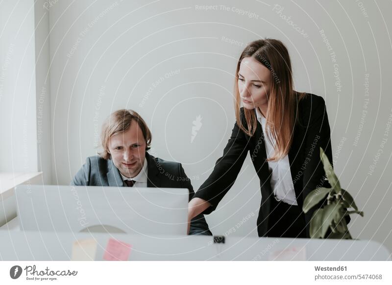 Businessman and woman working together at desk in office caucasian caucasian ethnicity caucasian appearance European employee employess smart smart casual