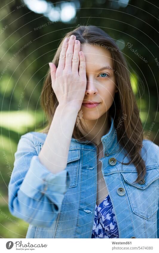 Portrait of young woman outdoors covering one eye females women eyes portrait portraits attractive beautiful pretty good-looking Attractiveness Handsome Adults