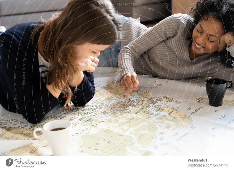 Friends putting pins on a map, planning their vacations maps female friends Holidays Travel destination Destination Travel destinations Destinations lying