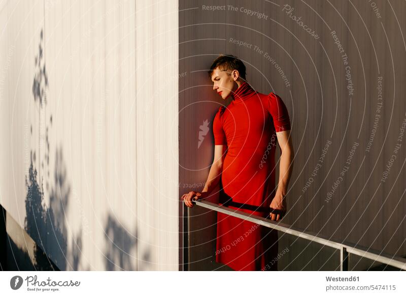 Non-binary male standing by wall during sunset color image colour image outdoors location shots outdoor shot outdoor shots sunsets sundown atmosphere Idyllic
