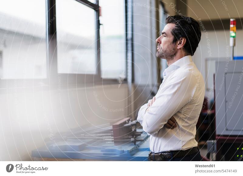 Pensive businessman in a factory looking out of window human human being human beings humans person persons caucasian appearance caucasian ethnicity european 1