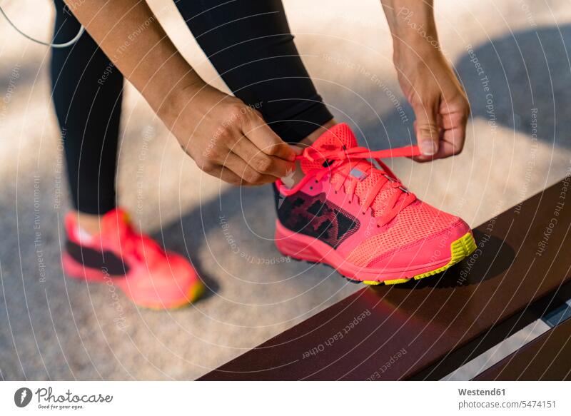 Close-up of sportive young woman tying her shoes exercise practising train training seasons summer time summertime summery colour colours magenta sports fit