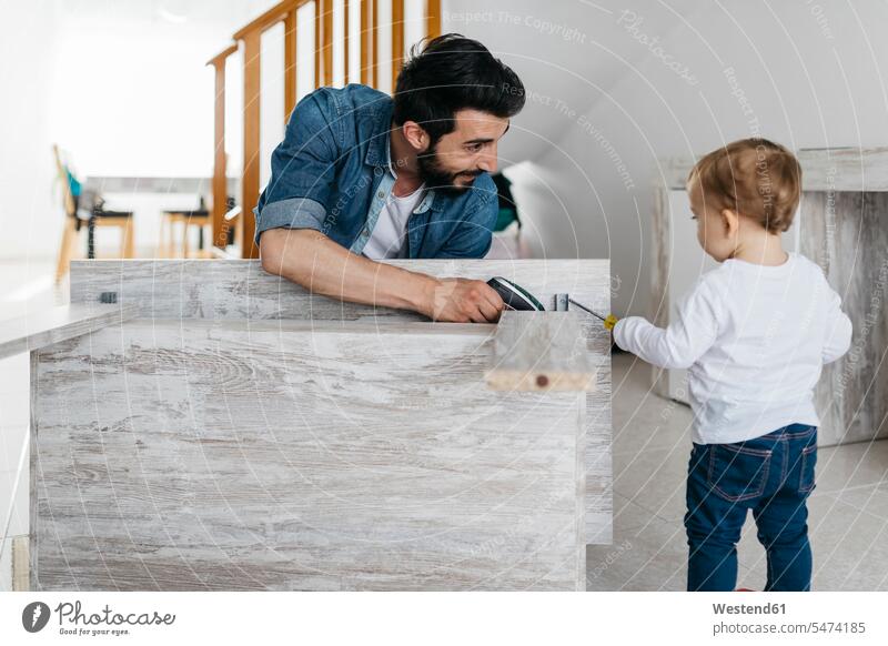 Father and daughter assembling a wooden table at home together DIY Doityourself Do it yourself Do-it-yourself Furniture Furnitures father pa fathers daddy dads