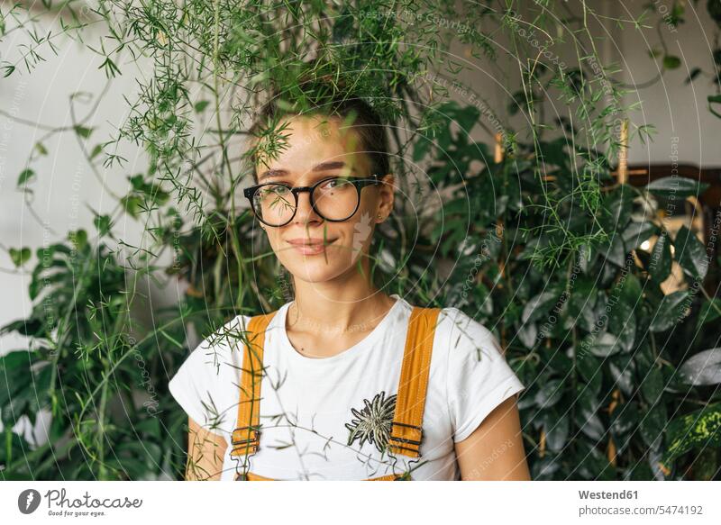 Portrait of a young woman surrounded by plants Occupation Work job jobs profession professional occupation Eye Glasses Eyeglasses specs spectacles At Work smile