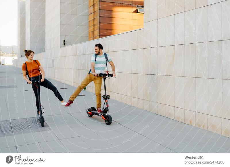 Happy couple with electric scooters in the city human human being human beings humans person persons caucasian appearance caucasian ethnicity european 2