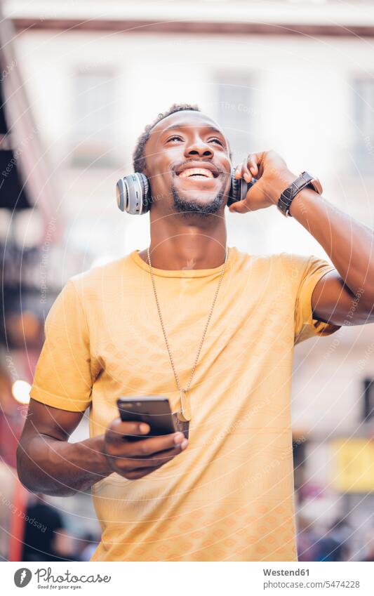 Portrait of happy man listening music with headphones and smartphone T- Shirt t-shirts tee-shirt jewelry necklaces headset telephone telephones cell phone
