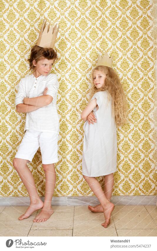 Boy and girl standing at a wall wearing cardboard crowns jewelry wall paper wall papers wallpapers play Retro retro revival Retro Styled Retro-Styled arrogance