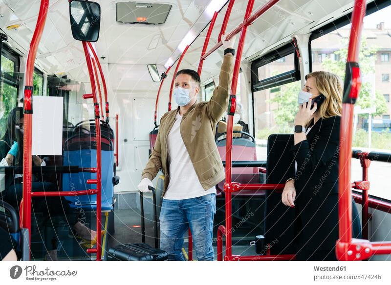 Passengers wearing protective masks in public bus, Spain transport motor vehicles road vehicle road vehicles buses busses telecommunication phones telephone