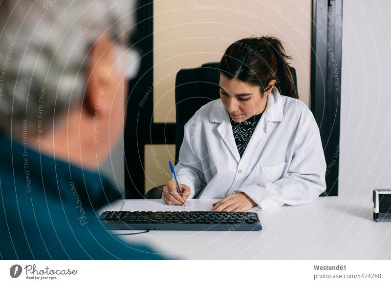 Doctor taking notes during a consultation in medical practice health healthcare Healthcare And Medicines medicine disease diseases ill illnesses sick Sickness