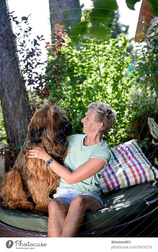 Smiling woman with her dog in the garden dogs Canine gardens domestic garden smiling smile females women pets animal creatures animals Adults grown-ups grownups