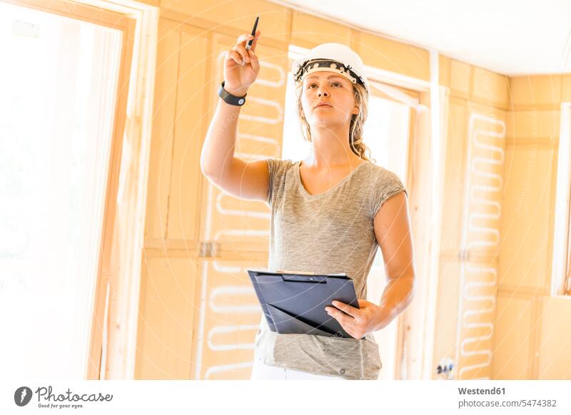 Young woman checking the construction of a new wooden house Occupation Work job jobs profession professional occupation blue collar blue collar worker