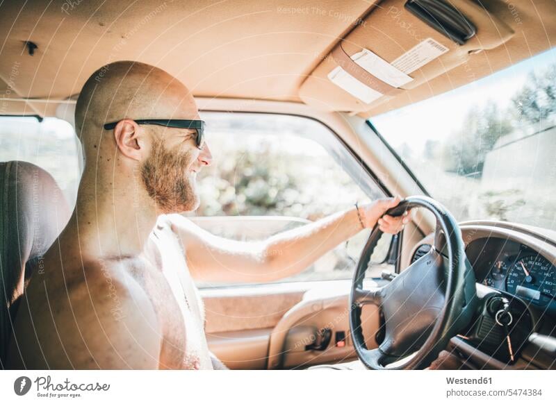 Barechested happy young man with sunglasses and beard on a road trip happiness men males sun glasses Pair Of Sunglasses Travel Road Trip roadtrip Road-Trip car