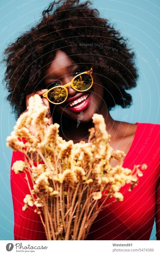Portrait of happy young woman with sunglasses and plants in studio human human being human beings humans person persons African black black ethnicity coloured