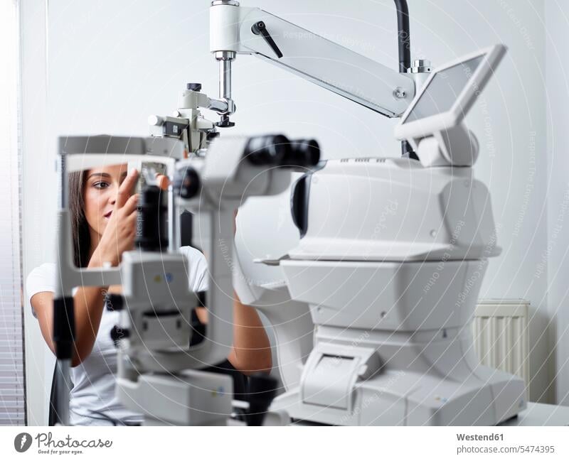 Optician, Young woman during eye test patient eyesight Optometry testing patients illness disease Sickness illnesses diseases healthcare and medicine medical
