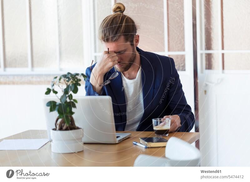 Tired businessman sitting at table in office human human being human beings humans person persons caucasian appearance caucasian ethnicity european 1