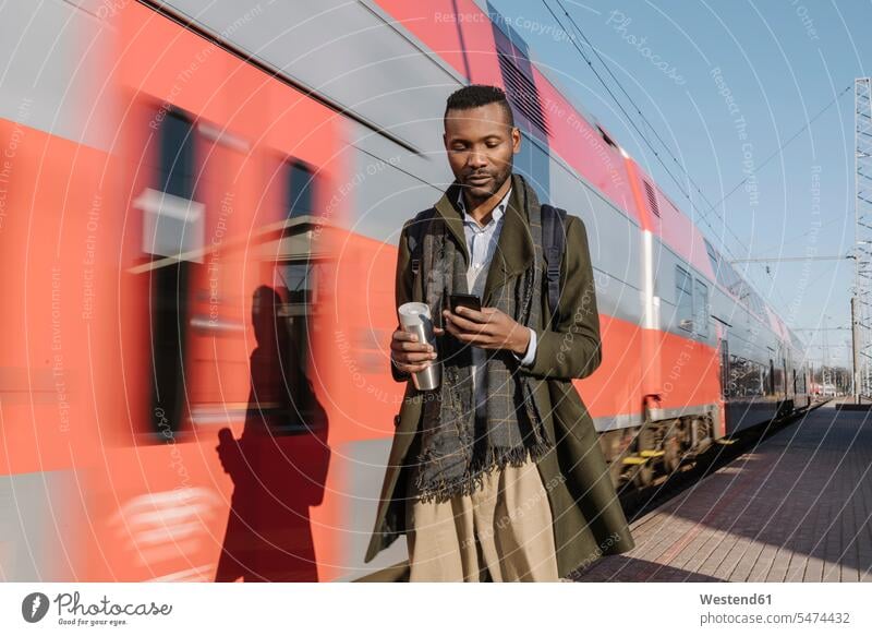 Portrait of stylish man using smartphone next to a train business life business world business person businesspeople Business man Business men Businessmen human