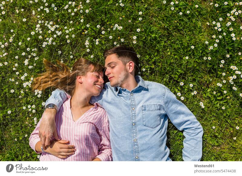 Happy young couple relaxing on grass in a park, overhead view Tuscany Falling In Love Grassy Quality Time resting toothy smile big smile open smile laughing