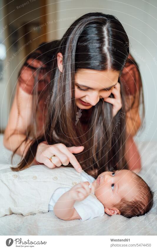 Happy mother playing with baby boy in bedroom color image colour image indoors indoor shot indoor shots interior interior view Interiors day daylight shot