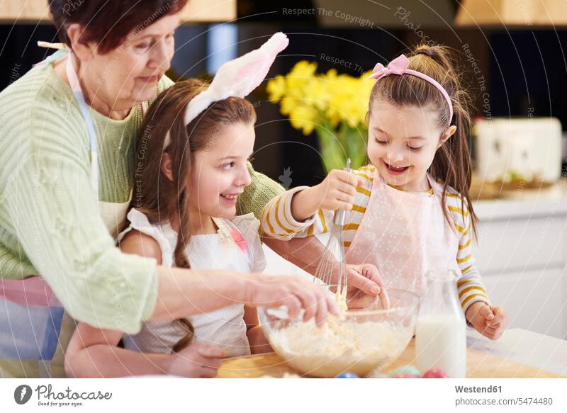 Grandmother and granddaughters baking Easter cookies in kitchen together Biscuit Cookie Cooky Cookies Biscuits grandmother grandmas grandmothers granny grannies