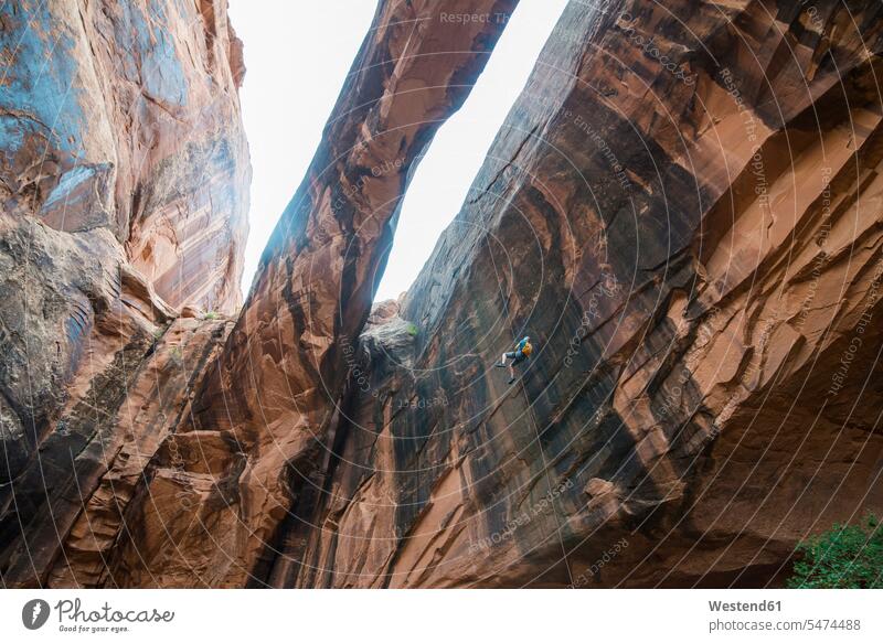 USA, Utah, Moab, Canyonering, Woman rapelling down a giant arch woman females women rock rocks canyon canyons canyoning Canyoneering Courage bravery Challenge