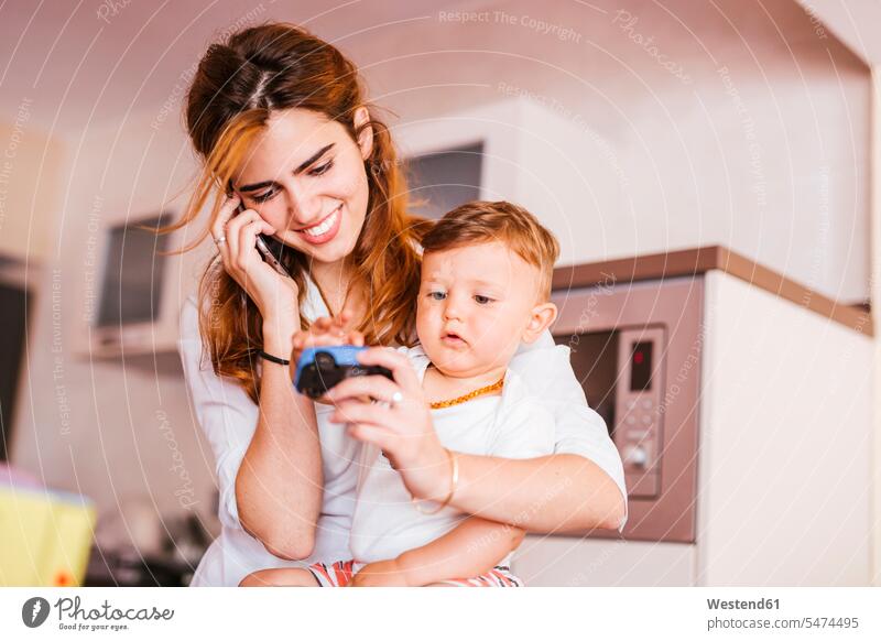 Happy mother with her son talking on the phone at home human human being human beings humans person persons caucasian appearance caucasian ethnicity european 2
