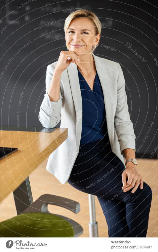 Portrait of confident blond businesswoman in conference room with blackboard Occupation Work job jobs profession professional occupation business life