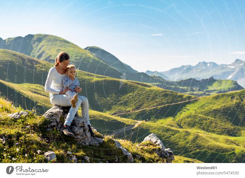 Germany, Bavaria, Oberstdorf, mother and little daughter on a hike in the mountains having a break mommy mothers mummy mama daughters hiking parents family