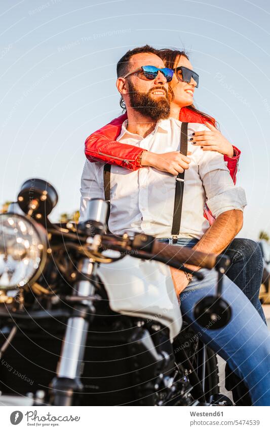Portrait of couple sitting on motorbike at evening twilight looking at distance human human being human beings humans person persons caucasian appearance