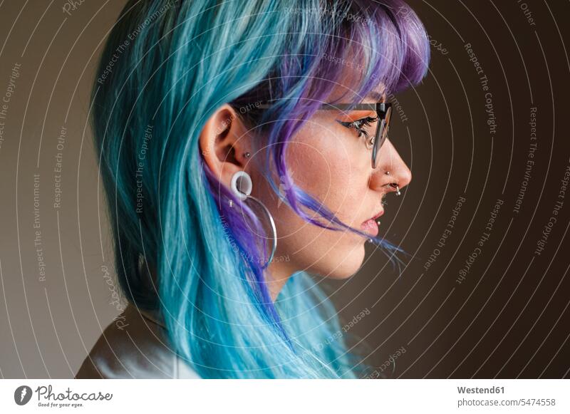 Close-up of thoughtful young woman with dyed hair and piercings against wall in old office color image colour image indoors indoor shot indoor shots interior
