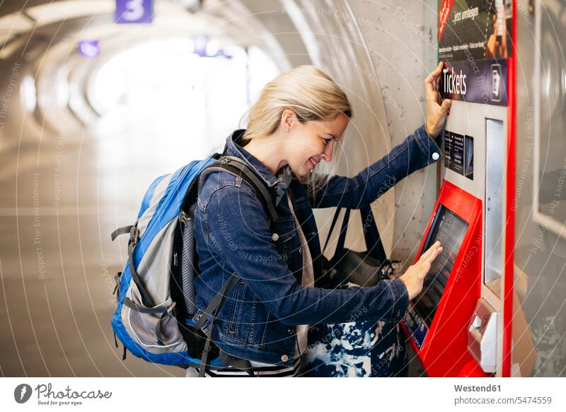 Smiling woman using ticket machine at the station Austria Traveller Travellers Travelers traffic Tickets commuter commuters subterranean Underground set off