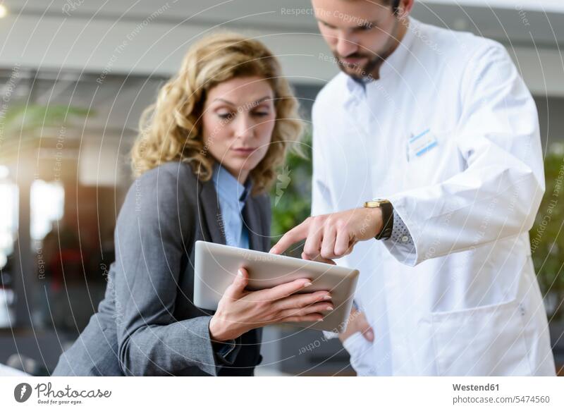 Businesswoman with tablet and doctor talking in hospital Occupation Work job jobs profession professional occupation business life business world