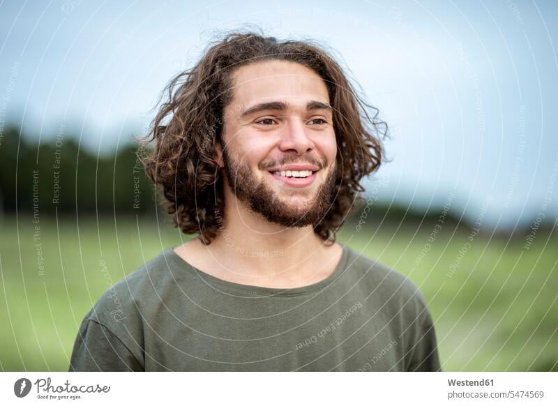 Portrait of happy young man outdoors happiness portrait portraits smiling smile Joy enjoyment pleasure Pleasant delight laughing Laughter long hair long-haired