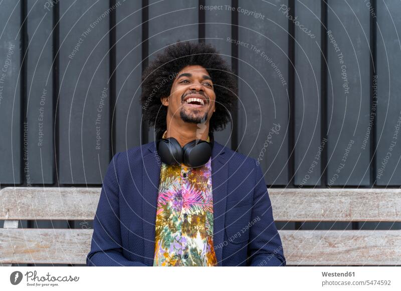 Laughing stylish man sitting on a bench human human being human beings humans person persons African black black ethnicity coloured African American