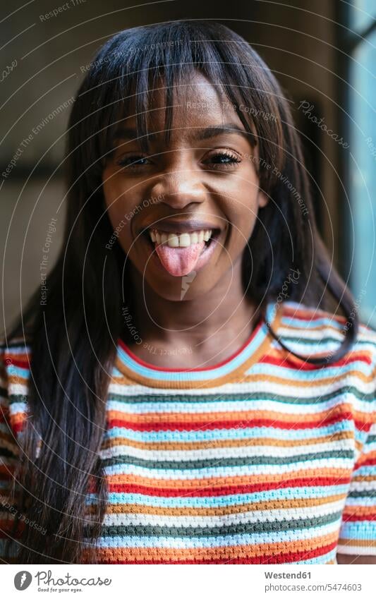 Portrait of laughing young woman sticking out tongue tongues portrait portraits Laughter females women mouth mouths people persons human being humans