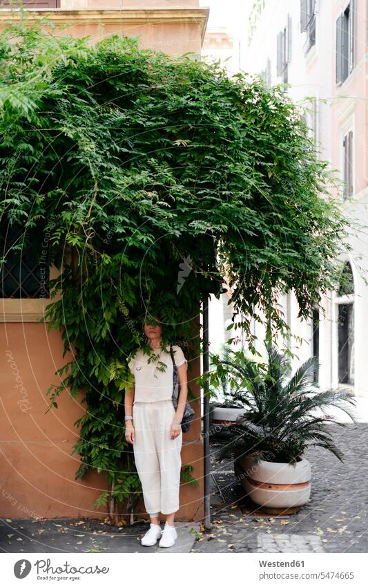 Woman hiding in a shrub in the city, Rome, Italy human human being human beings humans person persons caucasian appearance caucasian ethnicity european 1