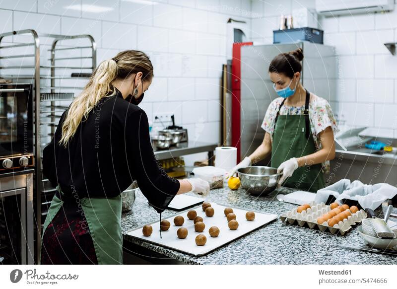 Female bakers making cookies at kitchen in bakery during COVID-19 color image colour image Spain indoors indoor shot indoor shots interior interior view
